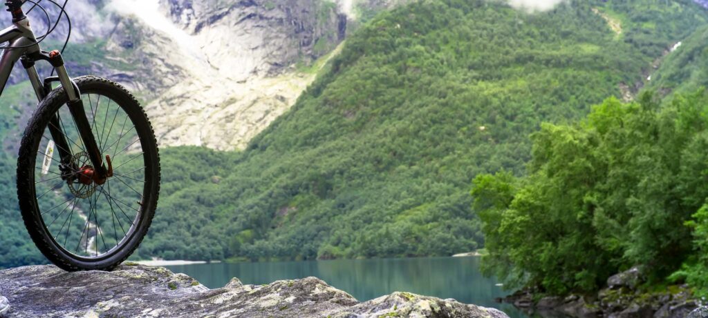 Mountain bike wheel and mountain lake landscape, Norway
