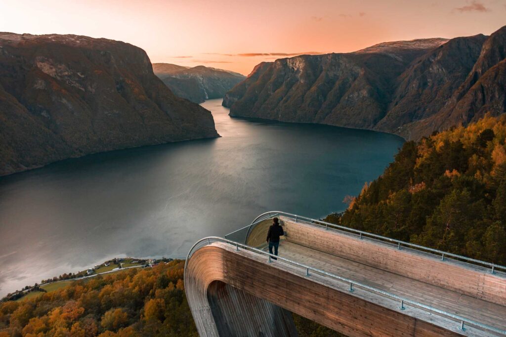 A Tourist Looks Out Over A Norwegian Fjord in the Fall