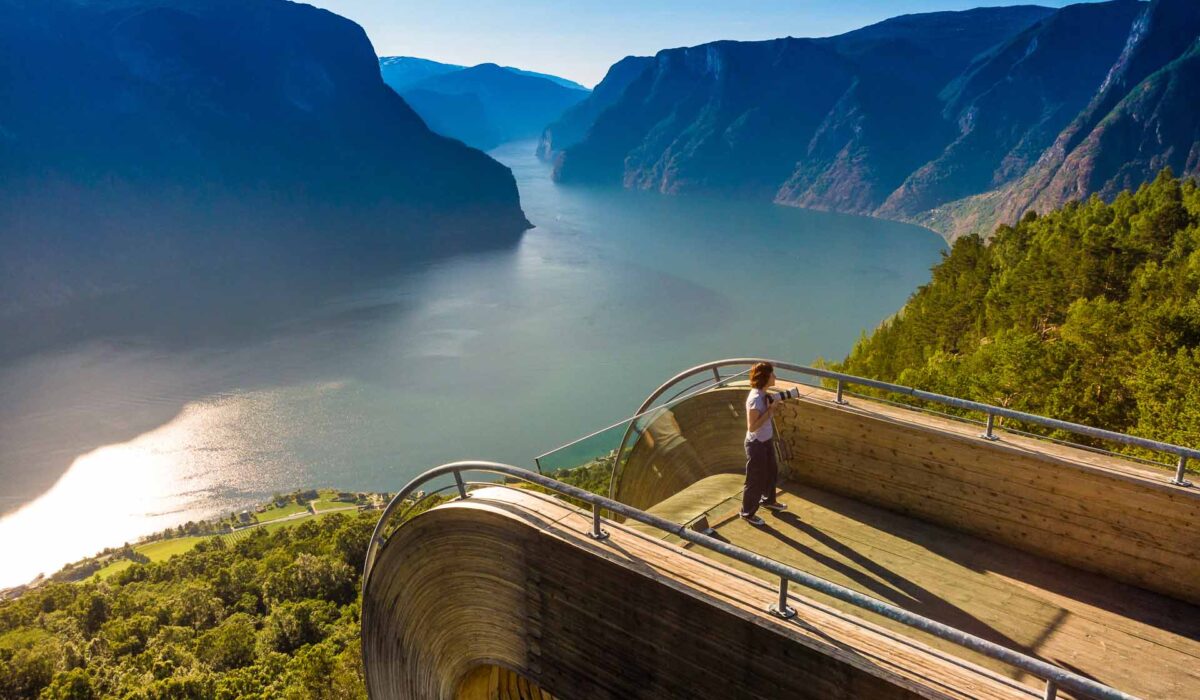 Tourist enjoying fjord view of Aurlandsfjord landscape from Stegastein viewing point. National tourist route Aurlandsfjellet.
